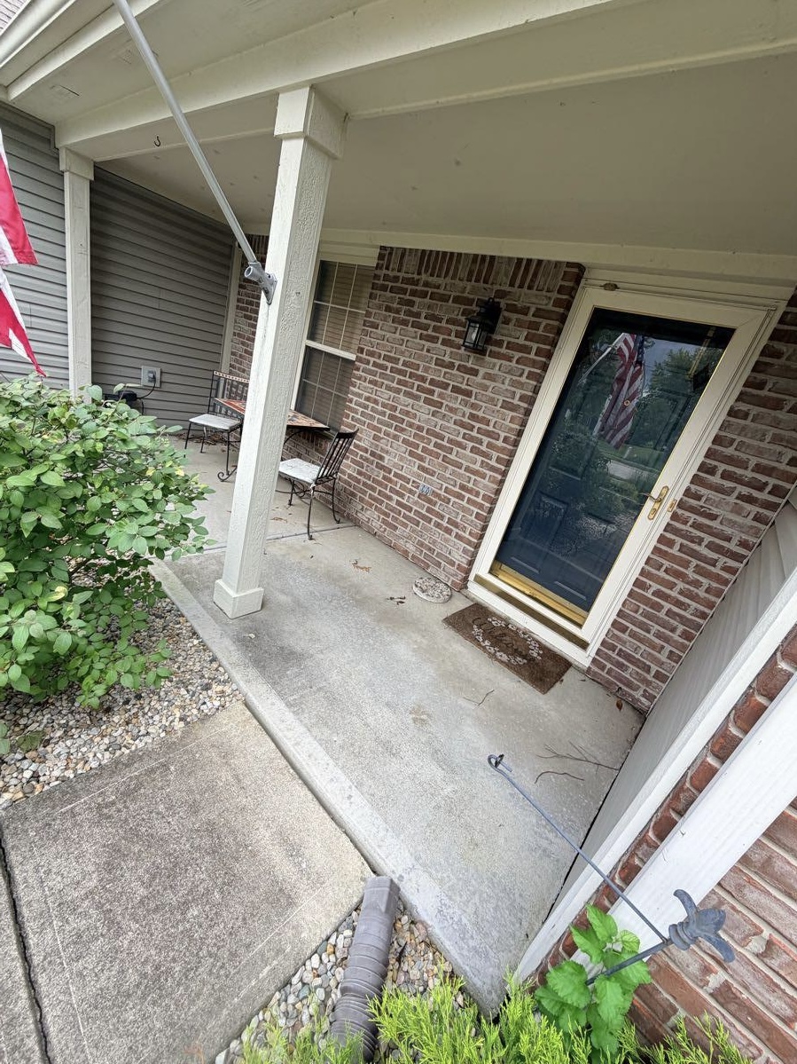 Covered front porch concrete before pressure washing