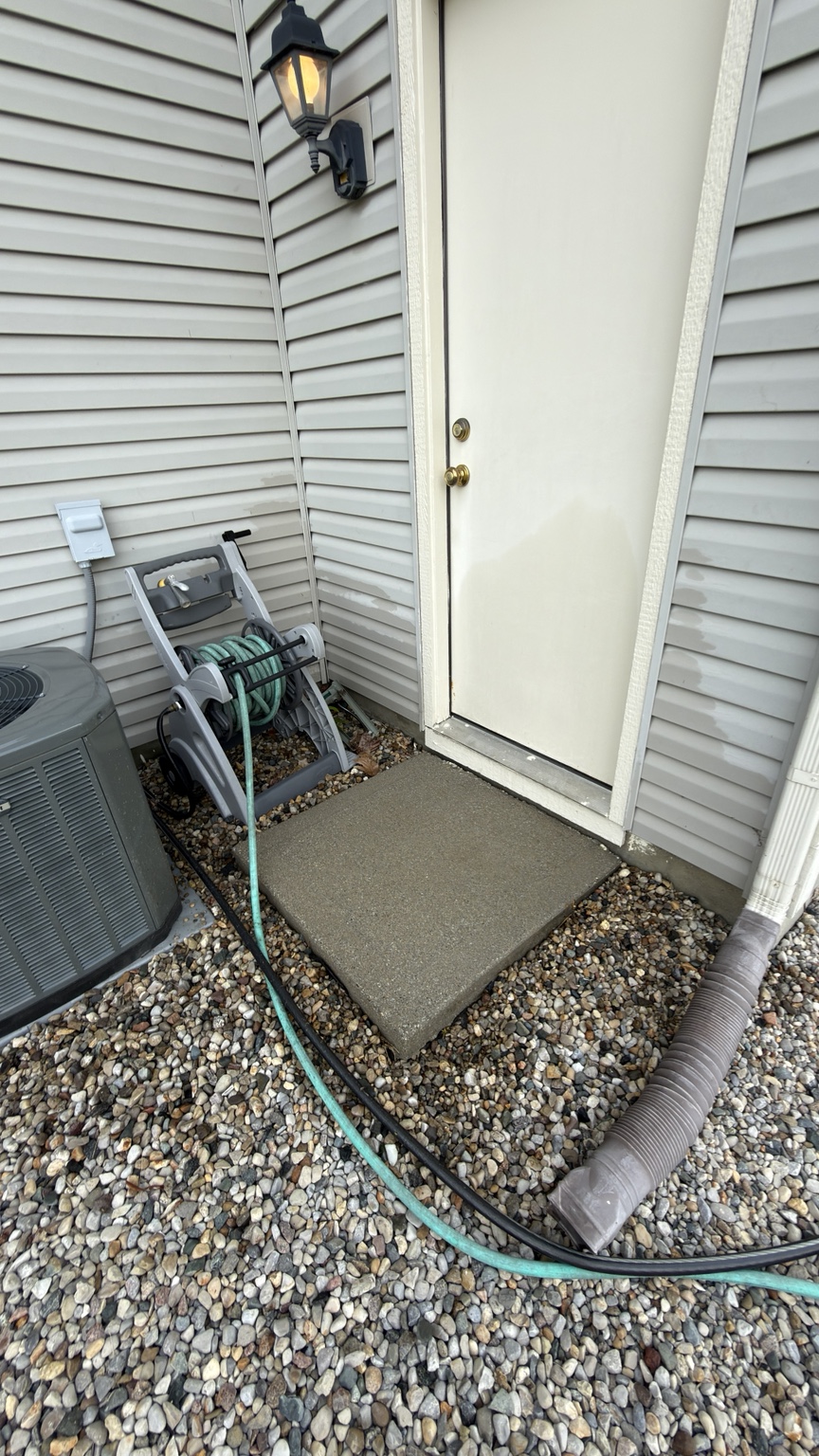 Small concrete pad by side door after pressure washing